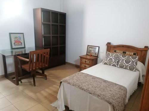 a bedroom with a bed and a desk and a chair at Casa Amagante, en Hoyo de Mazo in Villa de Mazo