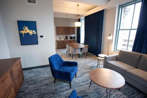 a living room with a couch and a table at BLU-Tique, Akron, a Tribute Portfolio Hotel in Akron