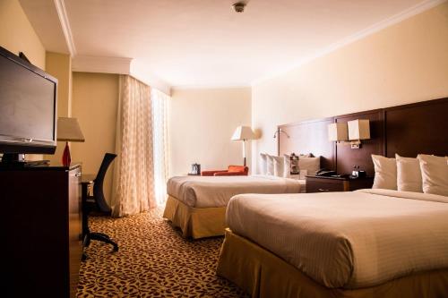 Habitación de hotel con 2 camas y TV de pantalla plana. en Marriott Venezuela Hotel Playa Grande, en Playa Grande