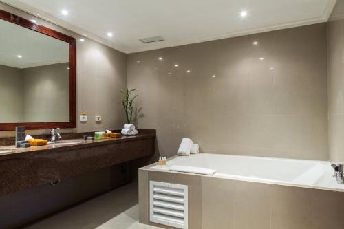 a bathroom with a large tub and a large mirror at Marriott Venezuela Hotel Playa Grande in Playa Grande