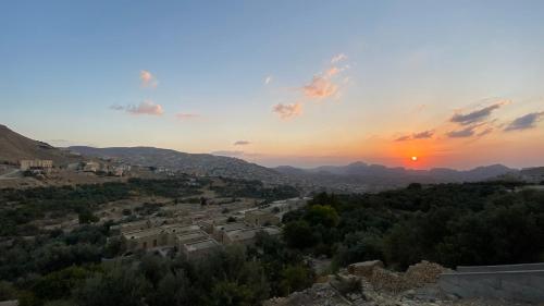 a view of a village at sunset at Petra Olive House in Wadi Musa