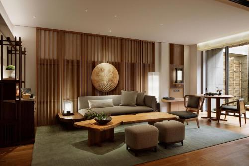 a living room with a couch and a table at HOTEL THE MITSUI KYOTO, a Luxury Collection Hotel & Spa in Kyoto