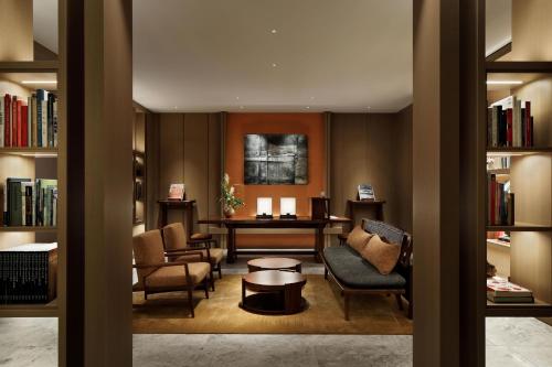 uma biblioteca com cadeiras, uma mesa e livros em HOTEL THE MITSUI KYOTO, a Luxury Collection Hotel & Spa em Quioto