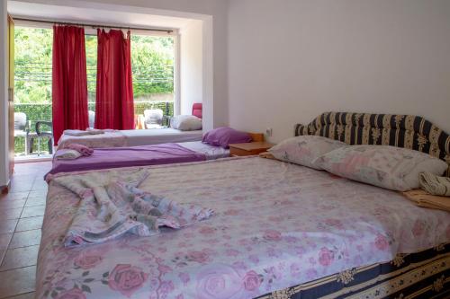 a bedroom with two beds and a couch and a window at Family Apartments Vukcevic in Čanj