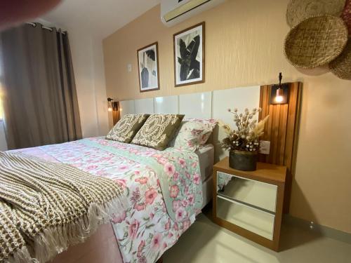 ein Schlafzimmer mit einem Bett und einem Nachttisch in der Unterkunft Hotel APART Zuccolotto 101 in Aracruz
