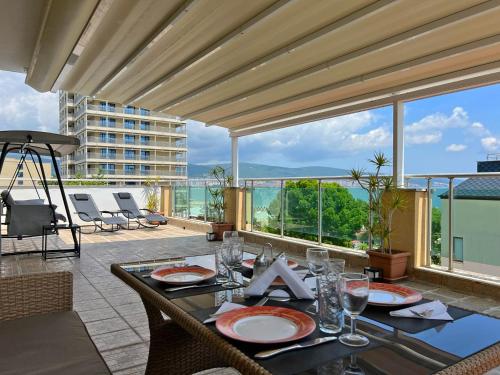 a dining table with a view of a balcony at Premium Apartment Midia Beach in Sunny Beach