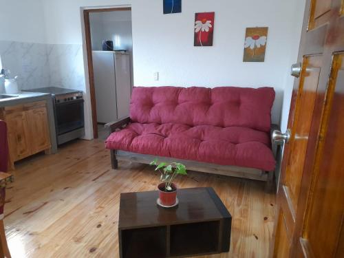 a red couch in a living room with a table at Mirador de Estrellas in Tupungato