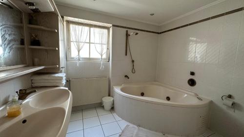 uma casa de banho branca com uma banheira e um lavatório em Cloud 9 em Dreieich