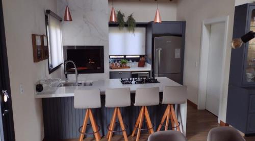 una cucina con bancone e sgabelli di Casa em Bom Jardim da Serra a Bom Jardim da Serra