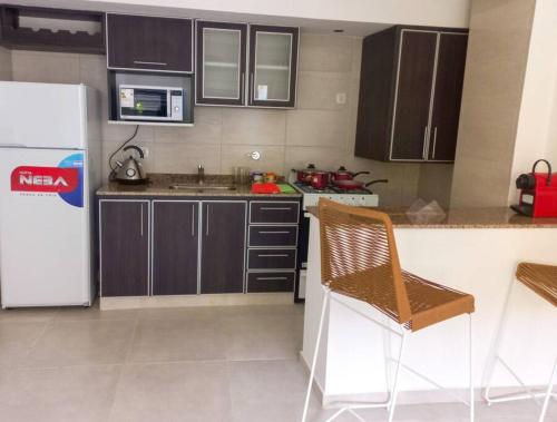 a kitchen with brown cabinets and a white refrigerator at Departamento de 2 amb. en Lomas Centro con terraza in Lomas de Zamora