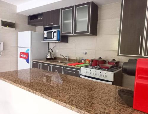 a kitchen with a white refrigerator and a stove at Departamento de 2 amb. en Lomas Centro con terraza in Lomas de Zamora