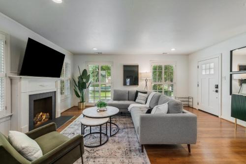 a living room with a couch and a fireplace at Sunset House - Luxury Pool and Hot Tub Retreat in Dallas