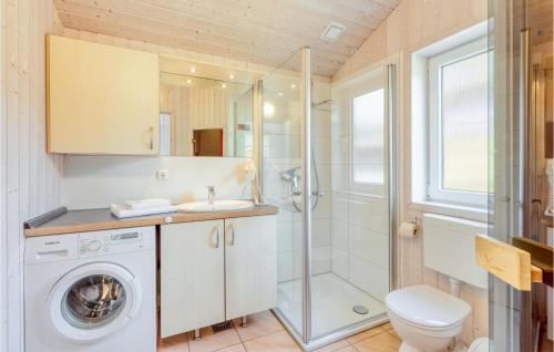 ein Bad mit einer Waschmaschine und einer Dusche in der Unterkunft Schatzkiste 3 - Dorf 4 in Travemünde
