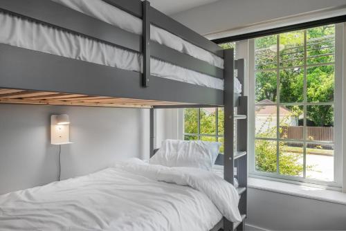 a bedroom with a bunk bed and a window at Sunset House - Luxury Pool and Hot Tub Retreat in Dallas