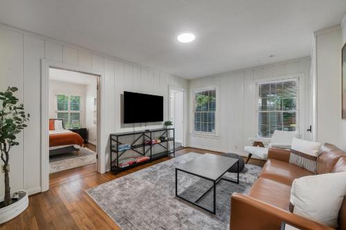 a living room with a couch and a tv at Sunset House - Luxury Pool and Hot Tub Retreat in Dallas