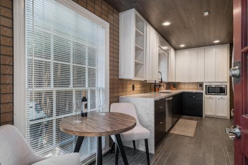 a small kitchen with a table and a window at Sunset House - Luxury Pool and Hot Tub Retreat in Dallas