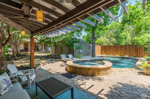 a patio with a pool with a wooden pergola at Sunset House - Luxury Pool and Hot Tub Retreat in Dallas