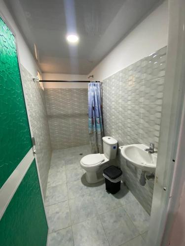 a bathroom with a toilet and a sink at Hostal Recuerdos del Tayrona in El Zaino