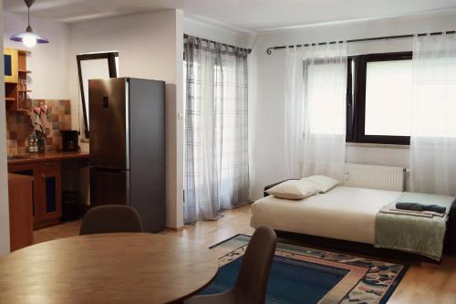a bedroom with a bed and a table and a refrigerator at Mieszkanie Warszawa 3 in Warsaw
