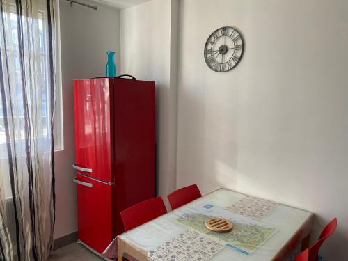une armoire rouge à côté d'une table avec des chaises rouges dans l'établissement Maison de l'Ancre centre Veules les roses avec parking privé et WIFI, à Veules-les-Roses