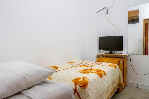 a bedroom with a bed and a television at Hotel Pousada Perdizes in São Paulo