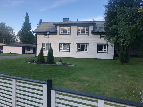 una casa con una valla blanca delante de un patio en Villa Kipakka, en Kihniö