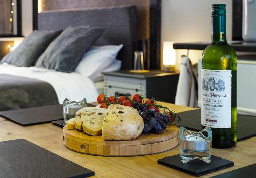 a table with a bottle of wine and a plate of bread and grapes at Beautiful studio apartment near the Norfolk Broads in Rackheath