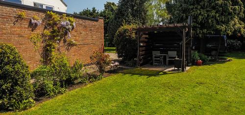 a backyard with a brick building and a shed at Beautiful studio apartment near the Norfolk Broads in Rackheath