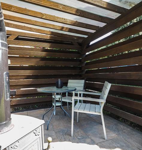 a patio with a table and chairs and a wooden wall at Beautiful studio apartment near the Norfolk Broads in Rackheath