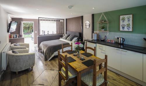 Rackheath的住宿－Beautiful studio apartment near the Norfolk Broads，厨房以及带1张床和1张桌子的卧室