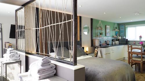 a bedroom with a large bed and a kitchen at Beautiful studio apartment near the Norfolk Broads in Rackheath