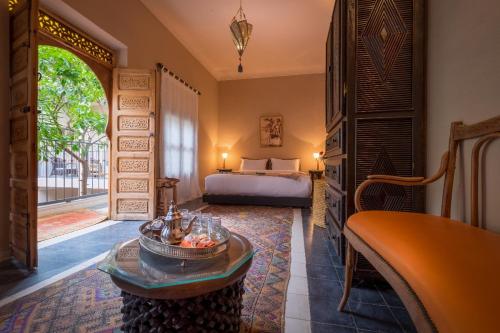 1 dormitorio con 1 cama y 1 mesa en una habitación en Riad Adrar, en Marrakech