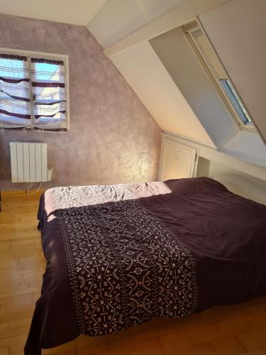 a bedroom with a large bed in a attic at Villa Bella à 300 m du Parc Fenestre in La Bourboule