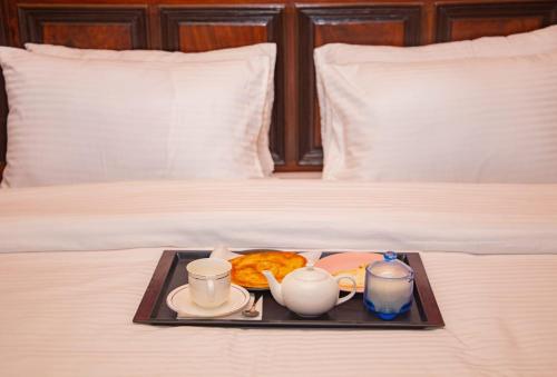 a tray of food and coffee on a bed at Hotel Inn Karachi in Karachi