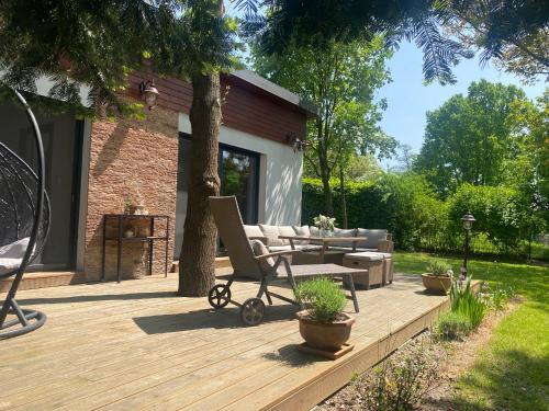 a wooden deck with a chair and a couch on it at Vila EVIO Třeboň in Třeboň
