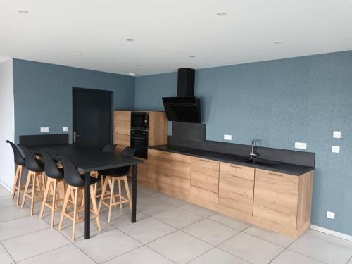 - une cuisine avec une table noire et des chaises dans l'établissement Nouveau Le Chant des Arbres, à Gelles