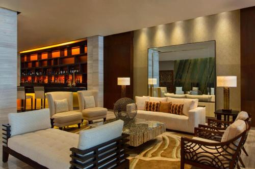 a living room with white furniture and a mirror at The Westin Panama in Panama City