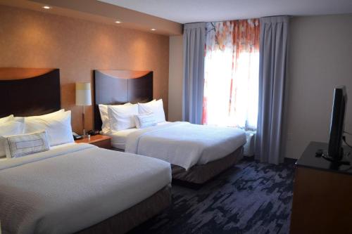 a hotel room with two beds and a flat screen tv at Fairfield Inn & Suites by Marriott Sault Ste. Marie in Sault Ste. Marie