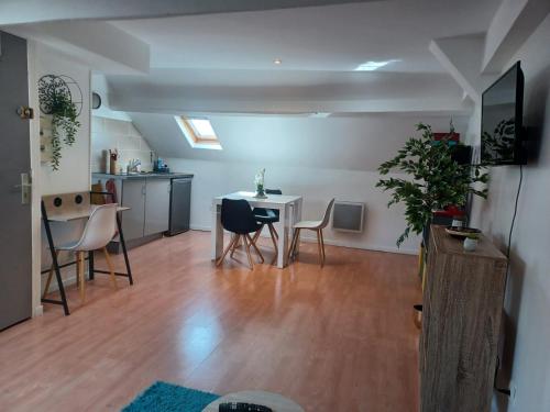 un salon avec une table et des chaises dans l'établissement Le Richelieu 3 chez Adrien, à Saint-Quentin