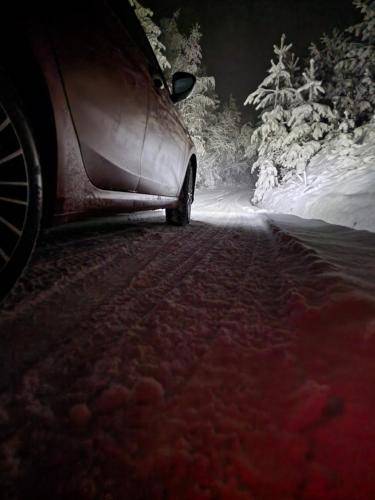a car parked on a snow covered road at night at Vila Vlasina in Vlasina Rid