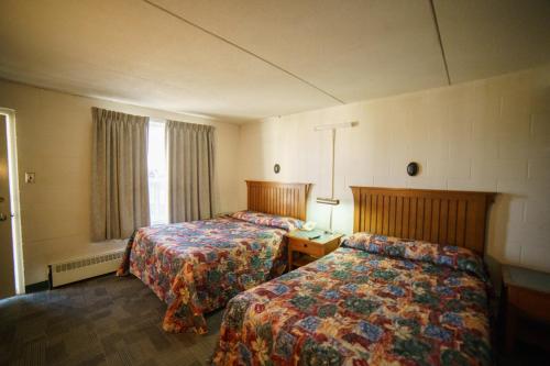 木斯久的住宿－卡波恩度假汽車旅館，酒店客房设有两张床和窗户。