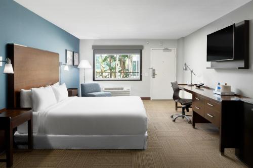 um quarto de hotel com uma cama grande e uma secretária em Four Points by Sheraton Anaheim em Anaheim