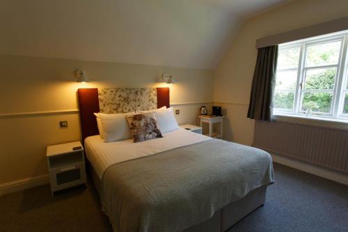 a bedroom with a large bed and a window at The Egerton Arms in Chester