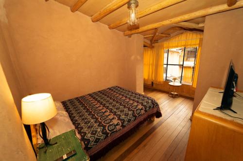 ein Schlafzimmer mit einem Bett, einer Lampe und einem Fenster in der Unterkunft Casa cabaña privada en el Valle Sagrado Urubamba in Urubamba