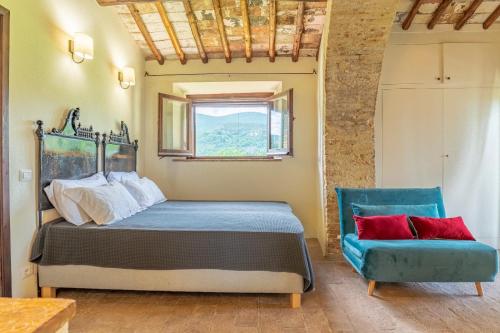 1 dormitorio con 1 cama y 1 silla azul en Podere Bargnano Cetona, Sleeps 14, Pool, WiFi, Air conditioning, en Cetona