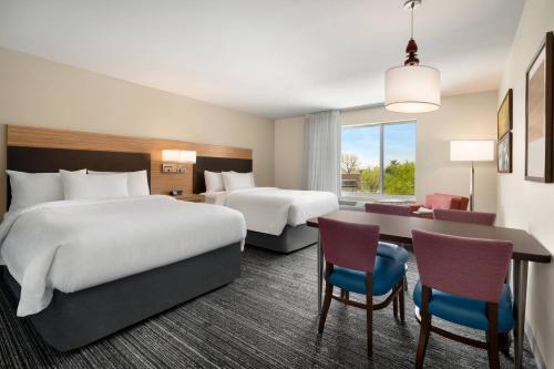 a hotel room with two beds and a desk at TownePlace Suites by Marriott Logan in Logan