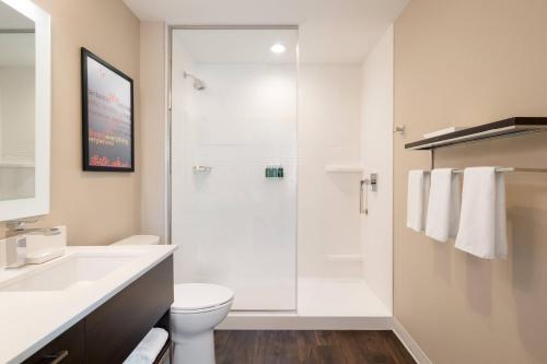 a bathroom with a shower with a toilet and a sink at TownePlace Suites by Marriott Logan in Logan