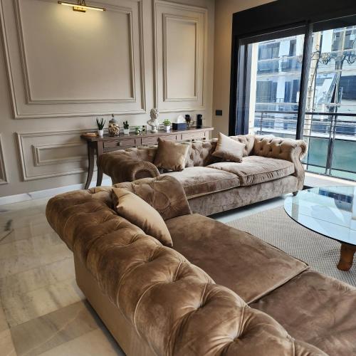 una sala de estar con 2 sofás marrones y una mesa. en Cosy Place en Casablanca