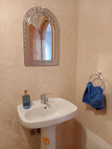 a bathroom with a white sink and a mirror at Dar diafa samira surf in Mirleft