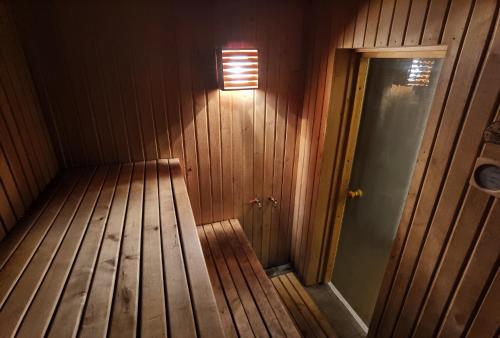 an empty wooden room with a light on the wall at Kemeri Roomstay & Sauna in Jūrmala
